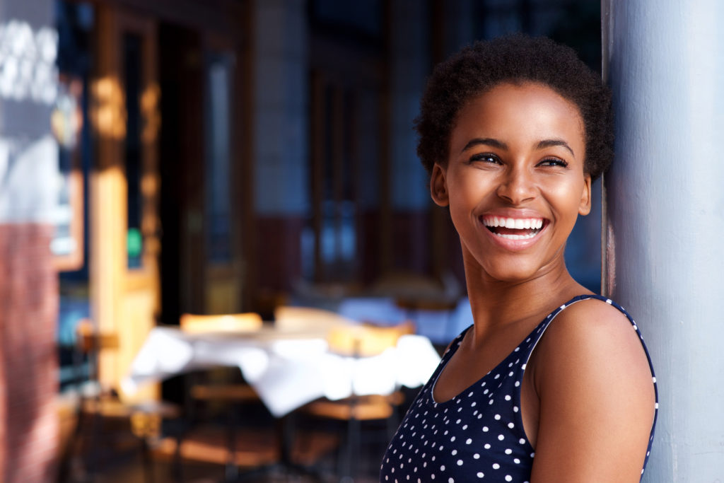 Side,Portrait,Of,Smiling,Young,Black,Woman,Standing,Outside