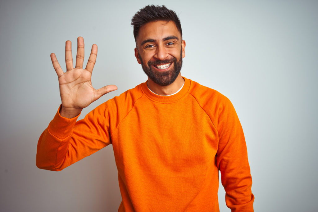 Young,Indian,Man,Wearing,Orange,Sweater,Over,Isolated,White,Background