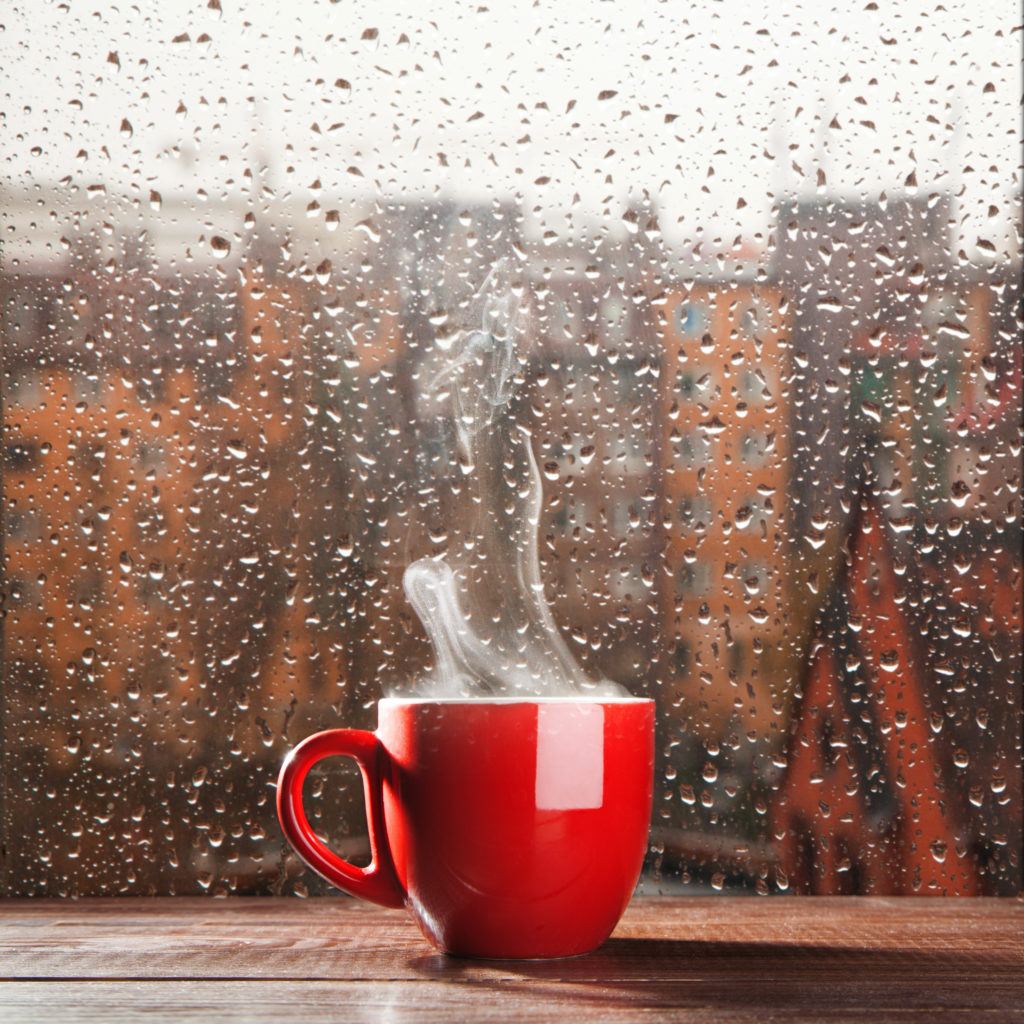 Steaming,Coffee,Cup,On,A,Rainy,Day,Window,Background