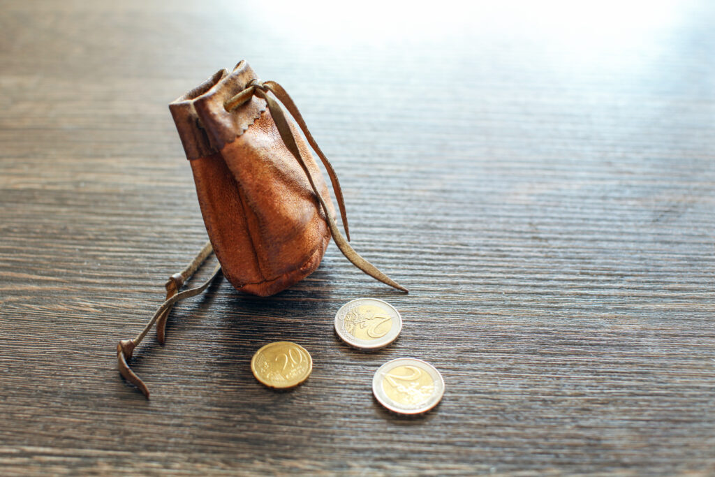 Vintage,Leather,Pouch,On,Wooden,Desk,,With,Euro,Coins,Next