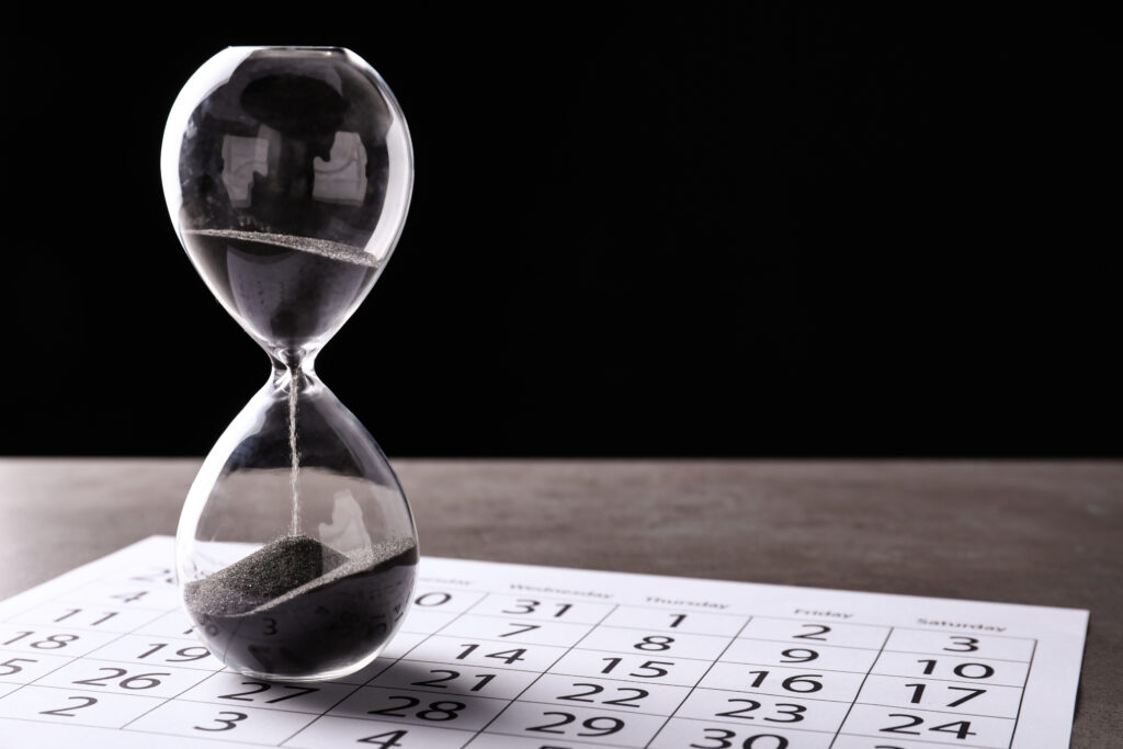 Crystal,Hourglass,With,Calendar,On,Table.,Deadline,Concept