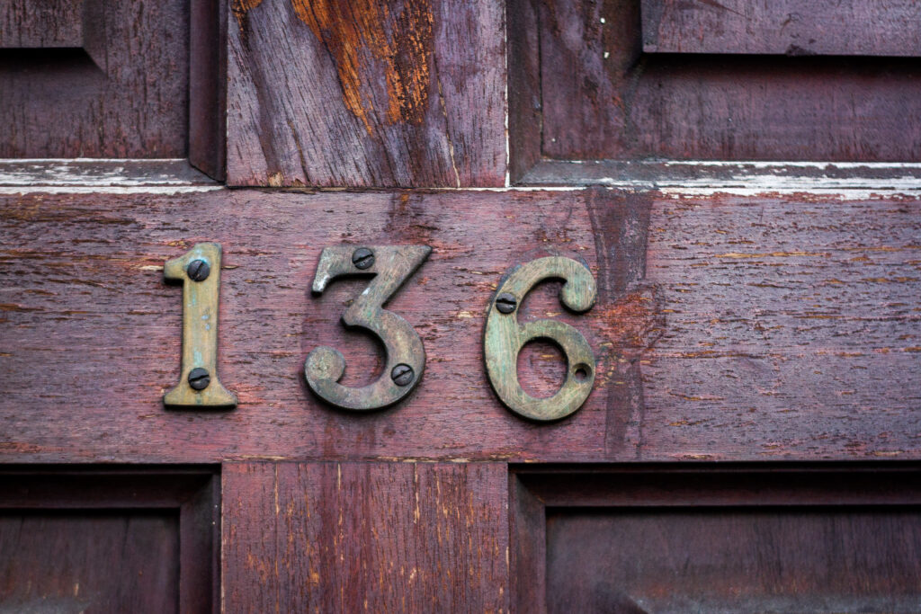 House,Number,136,On,A,Weathered,And,Worn,Wooden,Front