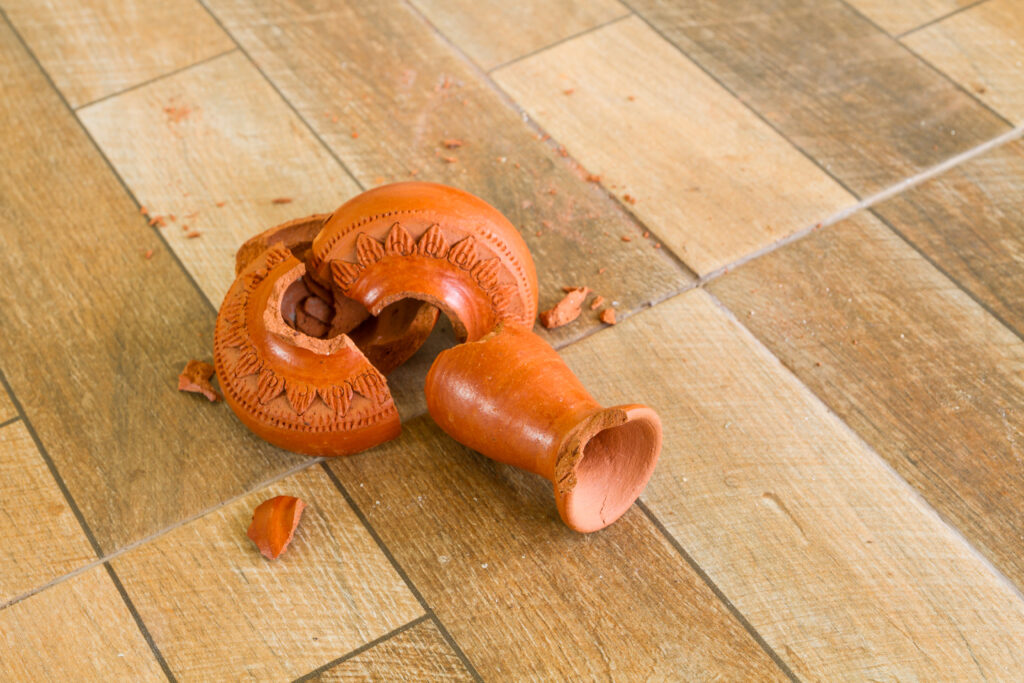 Green,Broken,Vase,On,A,Wooden,Floor