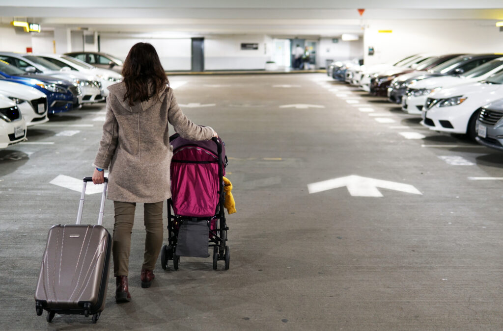 A,Young,Mother,Is,Seen,Walking,From,The,Back,for,Departures