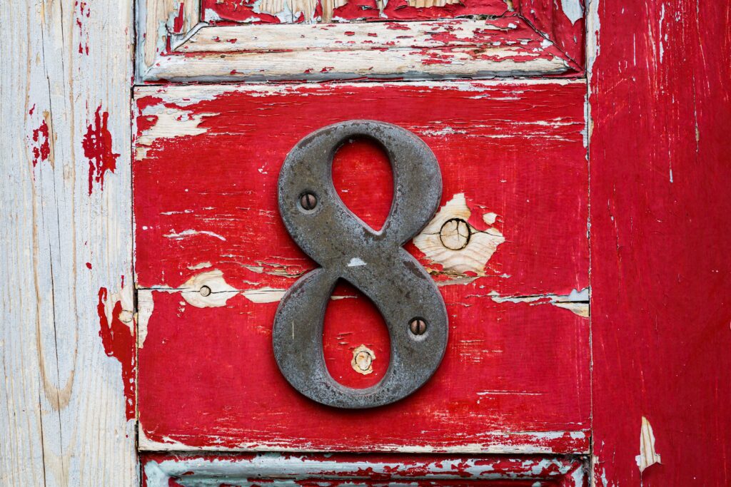 Metal,Number,Eight,On,An,Old,Front,Door,With,Red