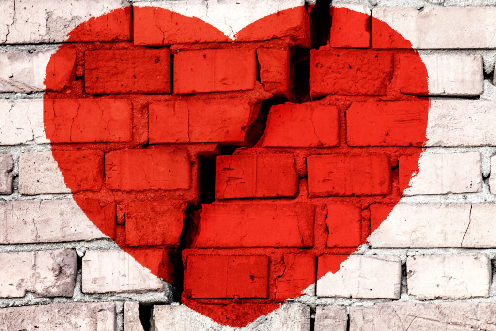 Red,Broken,Heart,On,The,Brick,Wall,With,Big,Crack