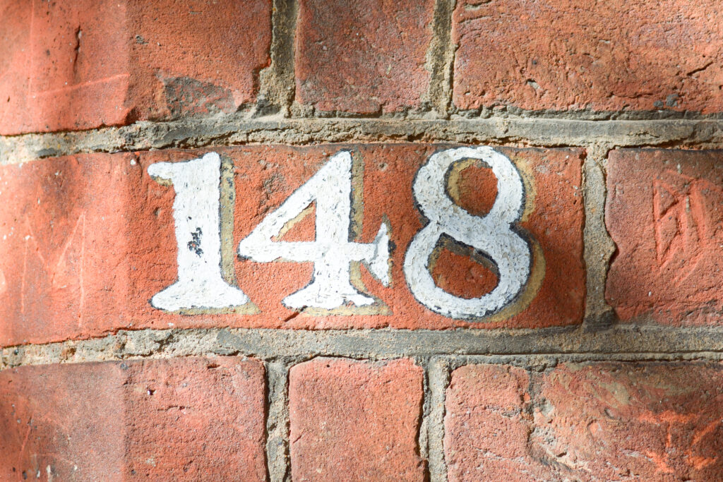 House,Number,148,Painted,Sign,On,Wall