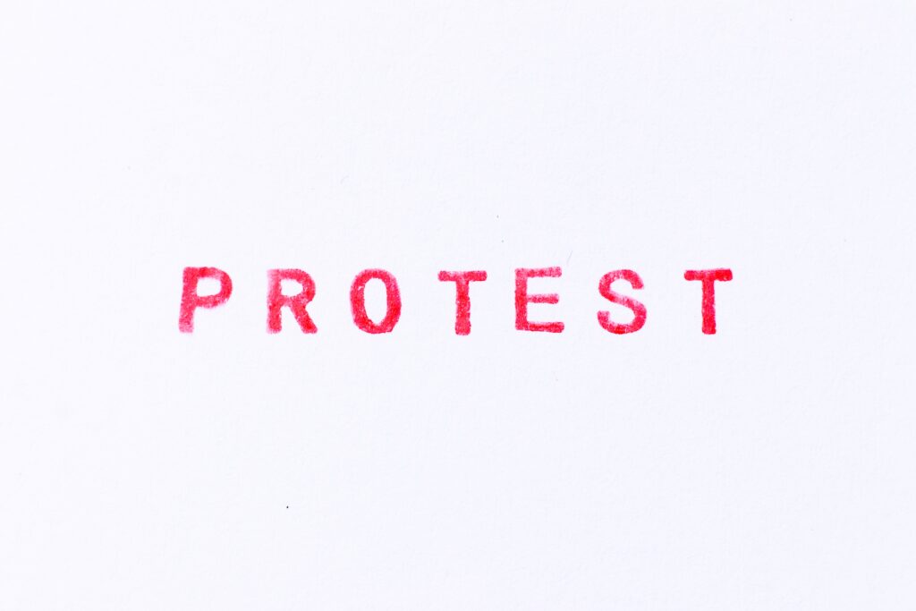 Red,Color,Ink,Rubber,Stamp,In,Word,Protest,On,White