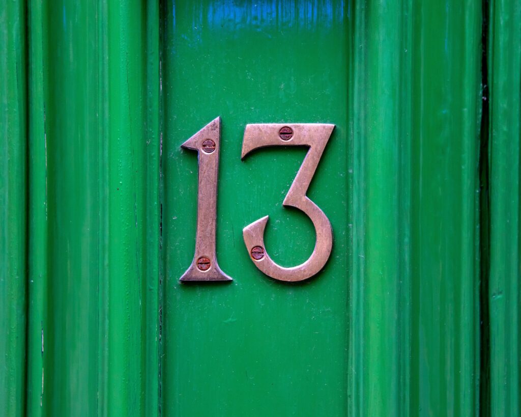 Close-up,Of,The,Number,13,On,A,Green,Door.