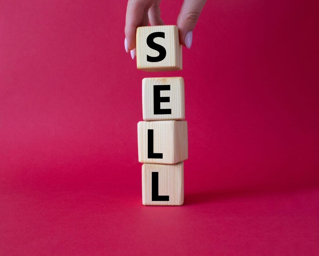 Sell,Symbol.,Concept,Word,Sell,On,Wooden,Cubes.,Businessman,Hand.